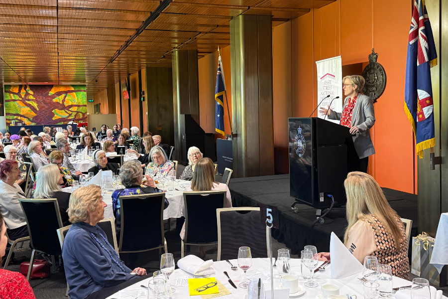 Women at various tables watch Professor Verity Firth speak at the Jessie Street National Women’s Library annual luncheon.